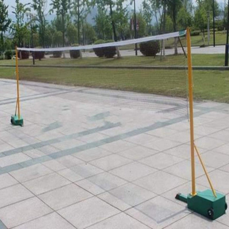 Load image into Gallery viewer, Verbeter je badmintonspel met het gebruikelijke badmintonnet, gemaakt van hoogwaardig materiaal, met een draagtas inbegrepen voor gemakkelijk transport. Het staat buiten op een betegeld terrein, omgeven door groene bomen en een graslandschap.
