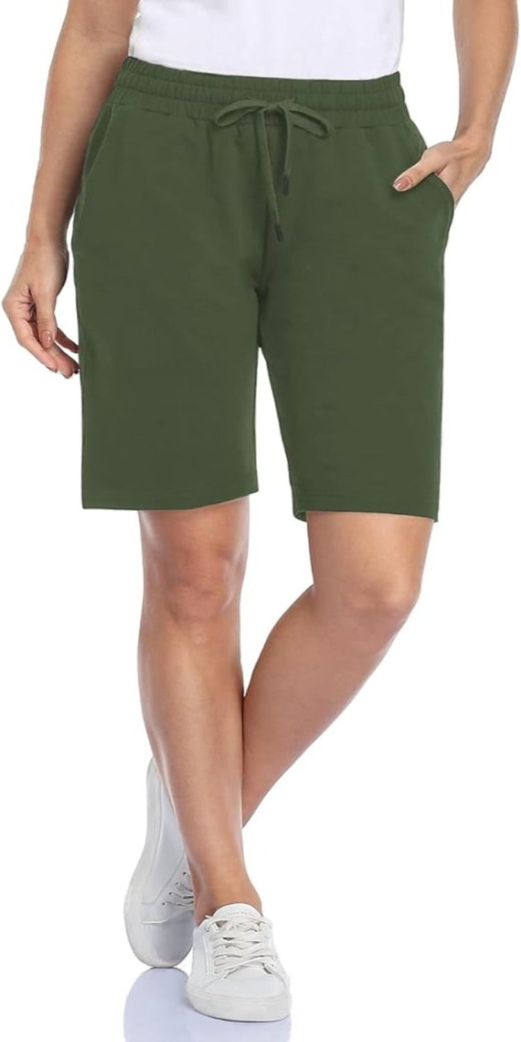 Laad afbeelding in Galerijviewer, Een persoon draagt een wit overhemd, een Bermudashort voor dames, bekend als comfortabel, veelzijdig en perfect voor elke gelegenheid met een verstelbare tailleband voor een comfortabele pasvorm, en witte sneakers.
