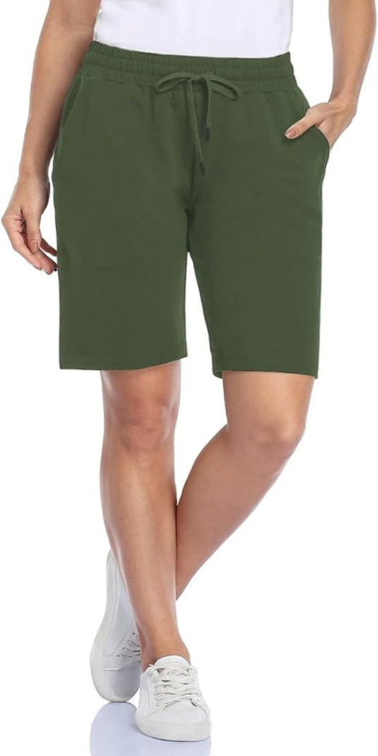 Een persoon draagt een wit overhemd, een Bermudashort voor dames, bekend als comfortabel, veelzijdig en perfect voor elke gelegenheid met een verstelbare tailleband voor een comfortabele pasvorm, en witte sneakers.