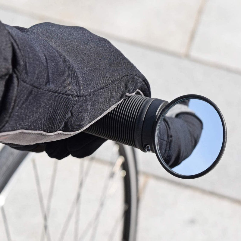 Laad afbeelding in Galerijviewer, Een gehandschoende hand houdt het fietsstuur vast, waarbij een Verbeter je fietstocht met de brede BM-45 stuureinde fietsspiegel de weg erachter weerspiegelt - een perfecte mix van duurzaamheid en functionaliteit.
