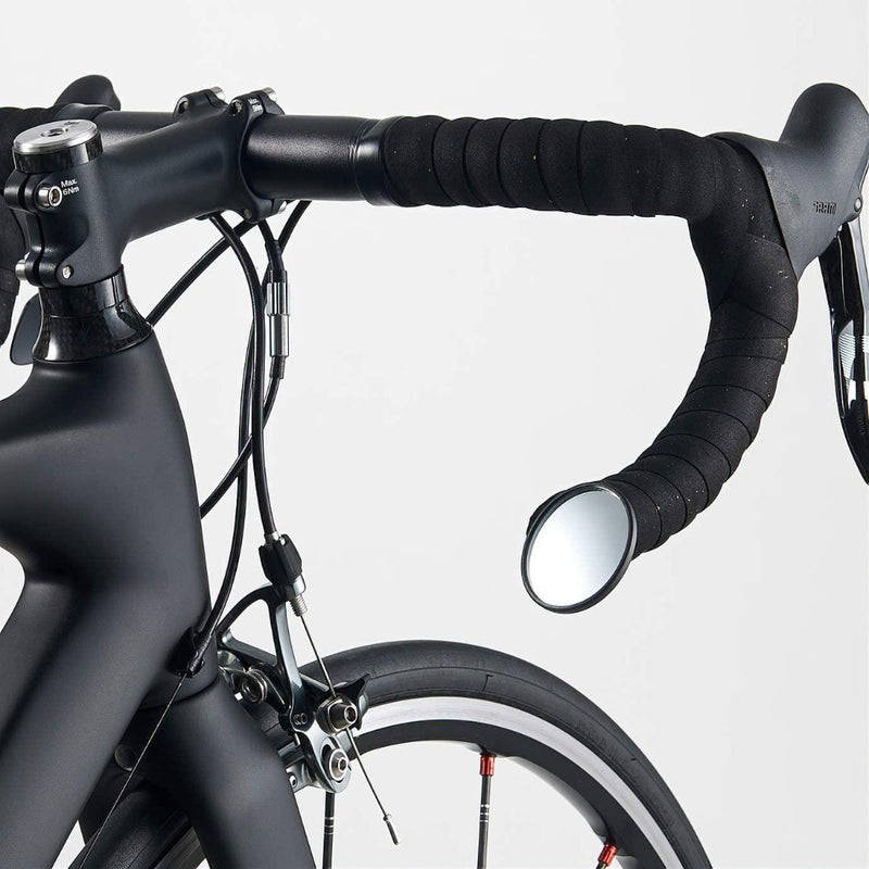 Laad afbeelding in Galerijviewer, Close-up van een zwart fietsstuur met de veelzijdige BM-45 stuureinde fietsspiegel. De afbeelding toont het frame, remsysteem en voorwiel tegen een effen achtergrond, wat het duurzame ontwerp benadrukt.
