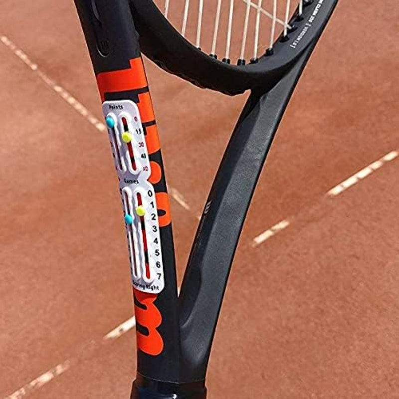Load image into Gallery viewer, Close-up van het Draagbaar tennis scorebord op een gravelbaan, met een aanpasbaar wegingssysteem met een schuifmechanisme. Het scorebord toont witte en rode kleuren en is ontworpen voor ITF-conformiteit, wat zorgt voor topprestaties in elke wedstrijd.
