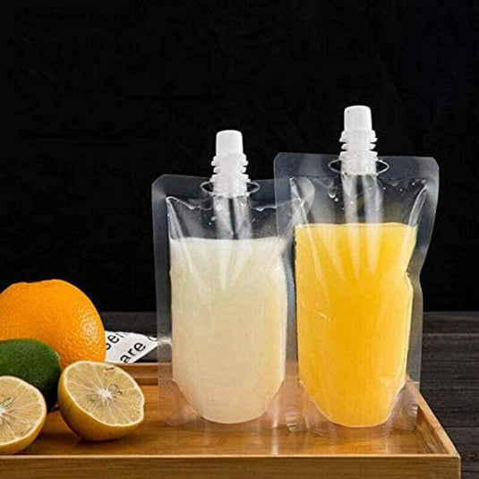 Twee transparante, lekvrije plastic zakjes met witte en oranje vloeistoffen zitten op hout, omringd door plakjes citroen, limoen en een sinaasappel. Gemaakt van BPA-vrije materialen, zijn deze Staande drinkzakken perfect voor versnaperingen voor onderweg.