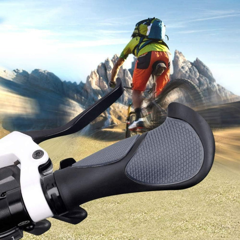 Load image into Gallery viewer, Een close-up van de Mtb handvatten, met antislip rubber en een ergonomische vorm. Op de achtergrond navigeert een fietser met helm en rugzak over een bergpad onder een helderblauwe lucht.

