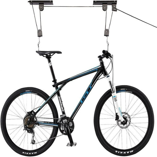 Een zwart-blauwe fiets, voorzien van een verende voorvork en Maxxis-banden, is opgehangen aan de "Optimaliseer uw ruimte en bescherm uw fiets met de innovatieve fietslift", met haken die het stuur en het zadel ondersteunen.