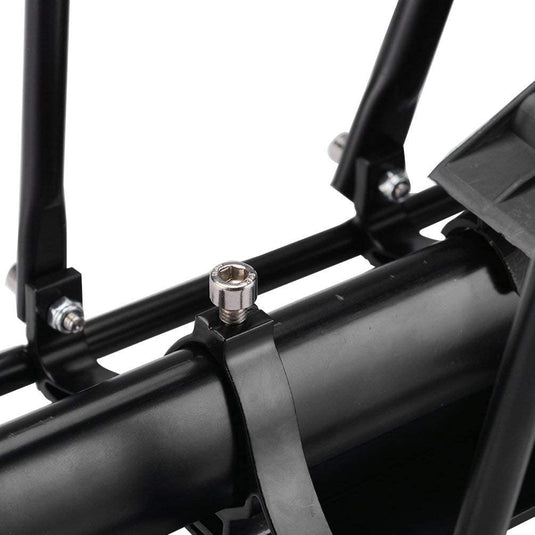 Een close-up van het zwarte metalen frame en de cilindrische stang benadrukt het robuuste design van de mountainbike. Bovenop een beugel is een zilveren schroef zichtbaar, wat de universele compatibiliteit met verschillende fietsendragers benadrukt, zoals de 'Ontdek de ultieme fiets bagagedrager voor mountainbike.'.