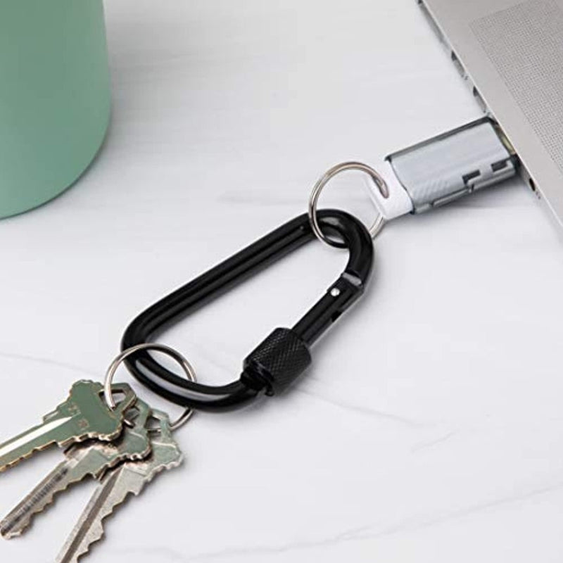 Laad afbeelding in Galerijviewer, Een zwarte karabijnhaak van &quot;Veiligheid en veelzijdigheid onderweg: Ontdek onze hoogwaardige aluminium karabijnhaken&quot; wordt bevestigd aan een USB-stick in een laptop, met drie sleutels op de karabijnhaak.
