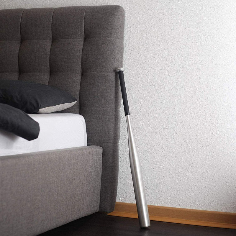 Load image into Gallery viewer, De Sla harder en betrouwbaarer met onze hoogwaardige honkbalknuppel met antislipwikkeling rust tegen het grijs gestoffeerde hoofdeinde naast een bed versierd met zachte kussens.
