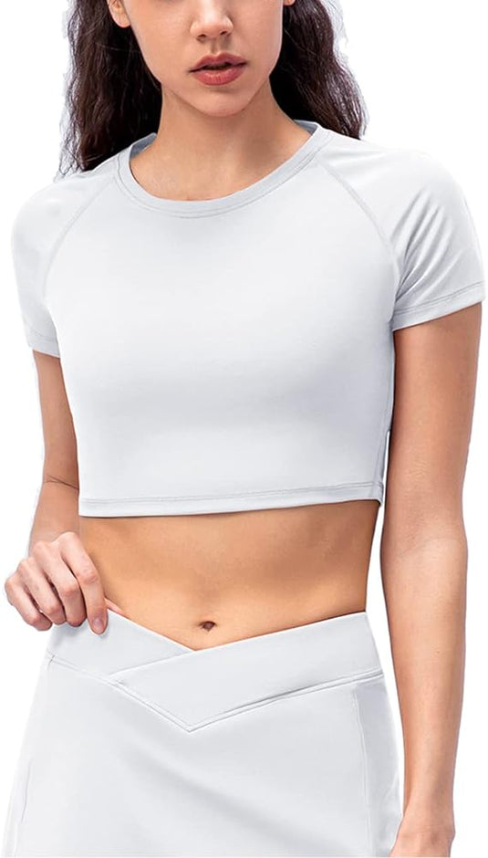 Een persoon met lang donker haar draagt een lichtgrijze Seamless dames fitness crop top en bijpassende rok tegen een effen witte achtergrond. Dit ensemble, gemaakt van ademend 4-way stretch materiaal, biedt een perfecte mix van stijl en comfort.