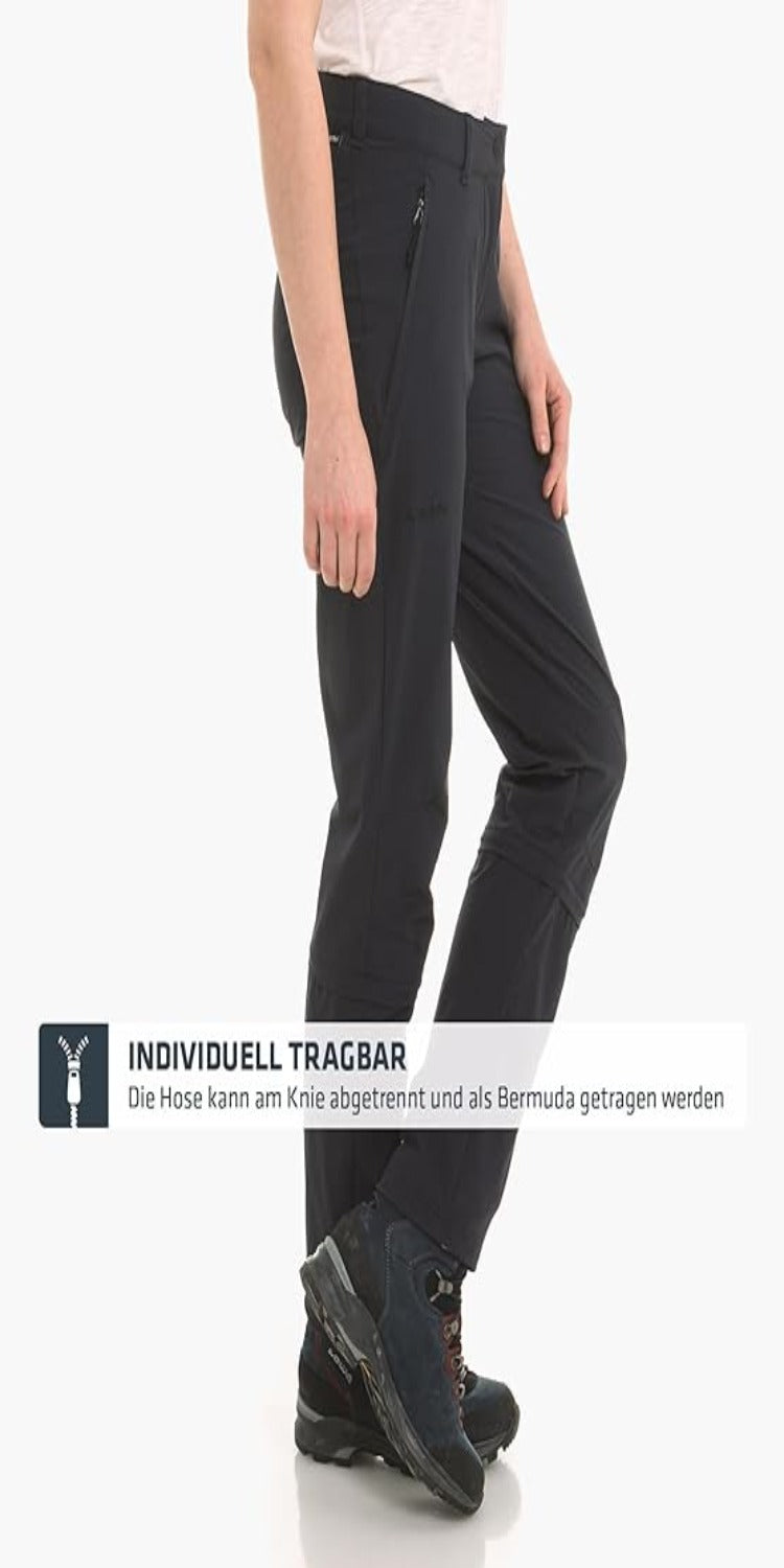 Laad afbeelding in Galerijviewer, Tegen een witte achtergrond draagt iemand een zwarte, omkeerbare broek en wandelschoenen. Deze 4-way stretchbroek verandert moeiteloos in een Bermuda short, gepromoot als &quot;Ontdek de perfecte wandelbroek voor dames - Zwart&quot; voor aanpasbare avonturen.
