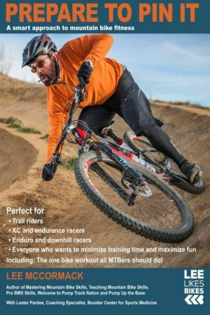 Load image into Gallery viewer, Een man in een oranje jas leunt behendig in een bocht terwijl hij mountainbiket op een onverharde weg. Deze tekst biedt essentiële tips voor mountainbikefitness en benadrukt Lee McCormack&#39;s &quot;Prepare to Pin It: A smart approach to mountain bike fitness: 2&quot; als uw ultieme gids.
