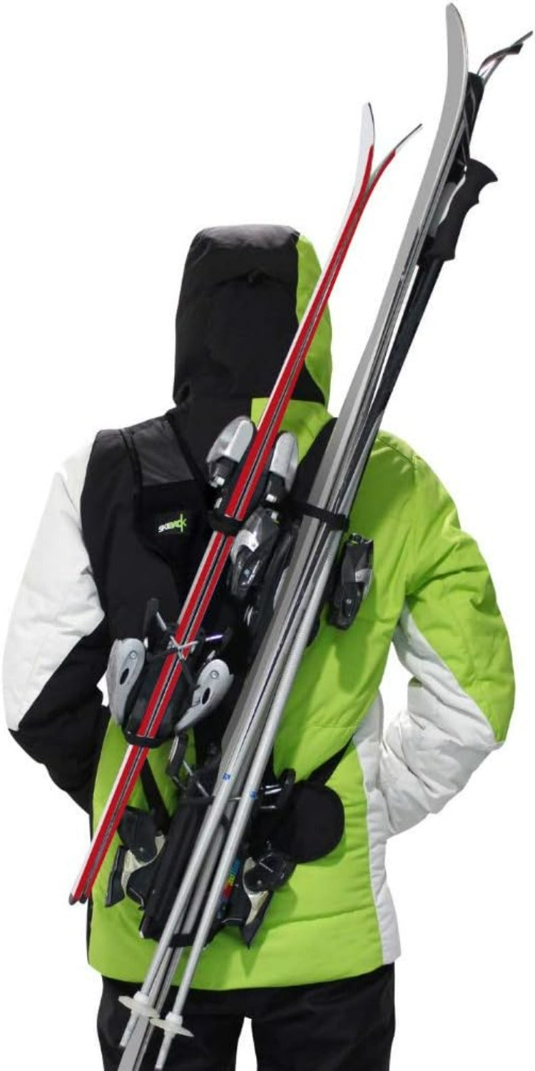 Load image into Gallery viewer, Een persoon in een groen-witte jas draagt ski&#39;s en stokken handsfree met de compacte skiback en geniet van het comfort van &quot;Skiën zonder je handen te gebruiken? Met de skiback is het mogelijk!.
