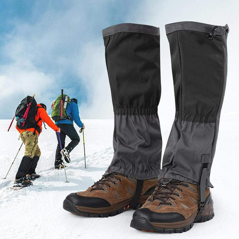 Laad afbeelding in Galerijviewer, Paar Ontdek het ultieme comfort en bescherming met onze sneeuwgamaschen voor volwassenen over laarzen met trekkers in sneeuw op de achtergrond.
