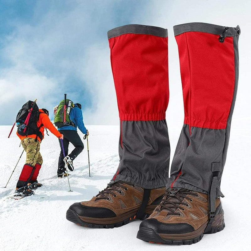 Laad afbeelding in Galerijviewer, Rode en grijze sneeuw gamaschen uit onze collectie &#39;Ontdek het ultieme comfort en bescherming met onze sneeuw gamaschen voor volwassenen&#39;, paar met wandelschoenen op de voorgrond terwijl twee klimmers op de achtergrond een besneeuwde heuvel beklimmen.
