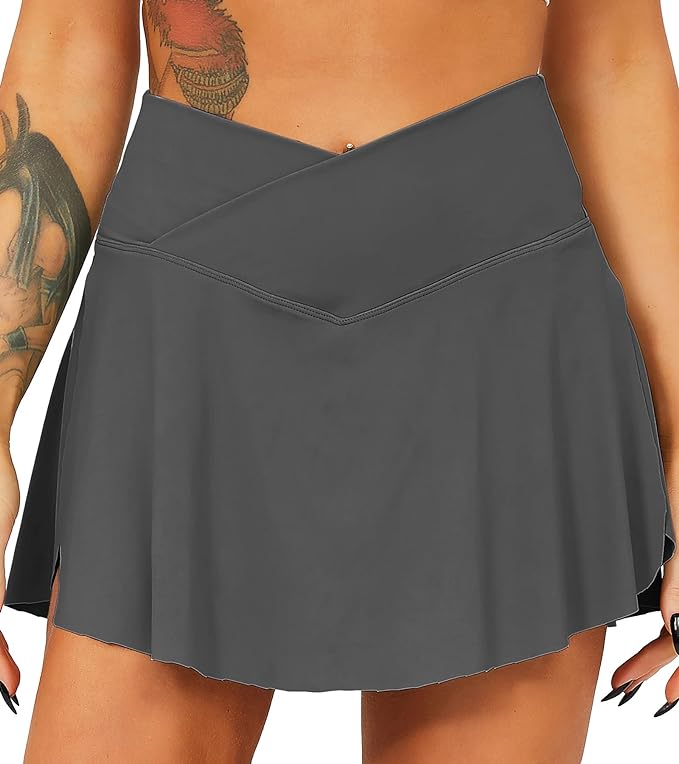 Laad afbeelding in Galerijviewer, Iemand die de &quot;Tennisrok met broek: de perfecte sportoutfit voor elke vrouw&quot; draagt, een donkergrijze rok met hoge taille, zijsplit en praktische zakken.
