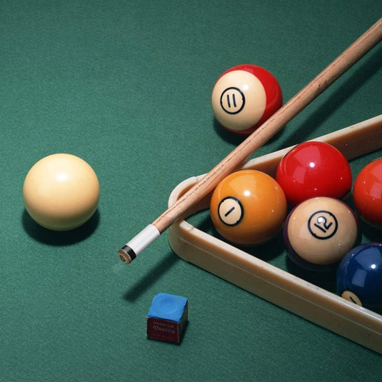 Een biljarttafel met een Verbeter je biljartspel met deze hoogwaardige biljartkeu en met gekleurde ballen genummerd 1, 11 en 12, met blauw pomeranskrijt op het groene oppervlak.