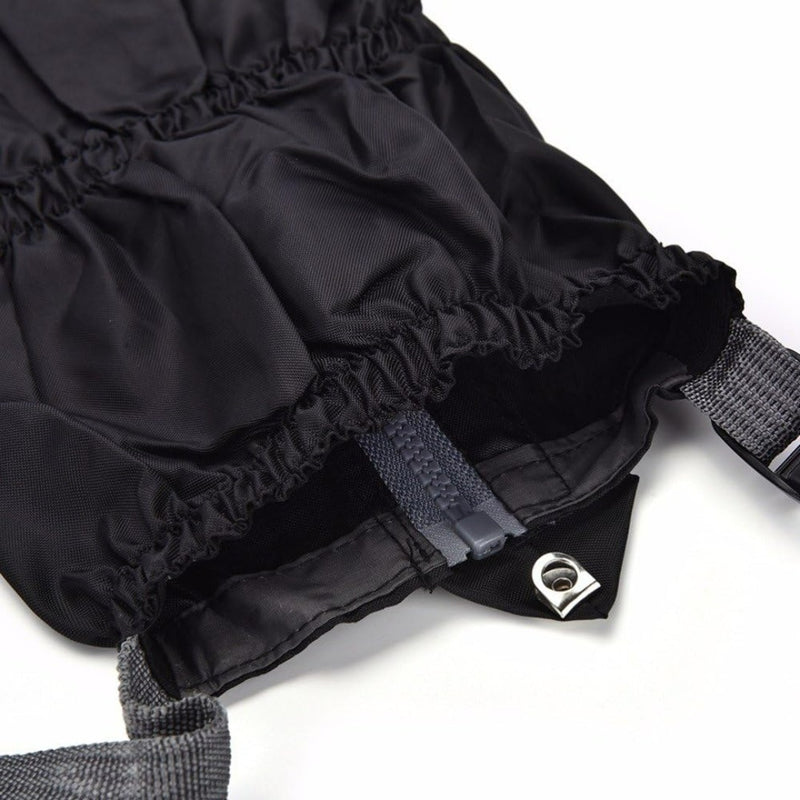 Load image into Gallery viewer, Close-up van een zwarte tas met trekkoord en grijze riemen, ideaal voor buitenactiviteiten, voorzien van een metalen doorvoertule en een binnenrits. Product: Gaiters - de ultieme bescherming voor al je buitenactiviteiten.
