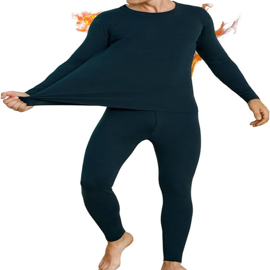Een persoon draagt een donkere thermische outfit en rekt het shirt uit hoogwaardige materialen. De vurige achtergrond benadrukt het product "Warm blijven en comfortabel bewegen in de winter met thermo ondergoed voor heren", waarbij de nadruk wordt gelegd op warmte en comfort in intense omstandigheden.