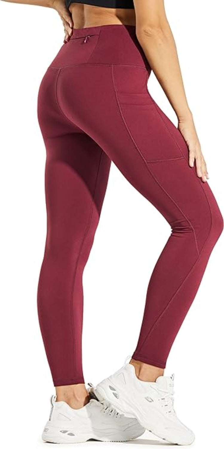 Laad afbeelding in Galerijviewer, Een persoon in kastanjebruine &quot;Warm, comfortabel en waterafstotend: de perfecte stille leggings voor dames&quot; en witte sneakers staat in een zijprofiel tegen een frisse witte achtergrond.
