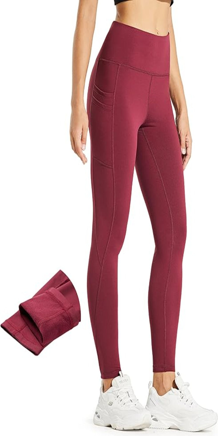 Laad afbeelding in Galerijviewer, Een persoon in een hoog getailleerde kastanjebruine legging met zakken, gecombineerd met witte sneakers. De afbeelding toont de gevouwen &quot;Warm, comfortabel en waterafstotend: de perfecte thermische leggings voor dames,&quot; met de nadruk op hun bruikbaarheid en stijl.
