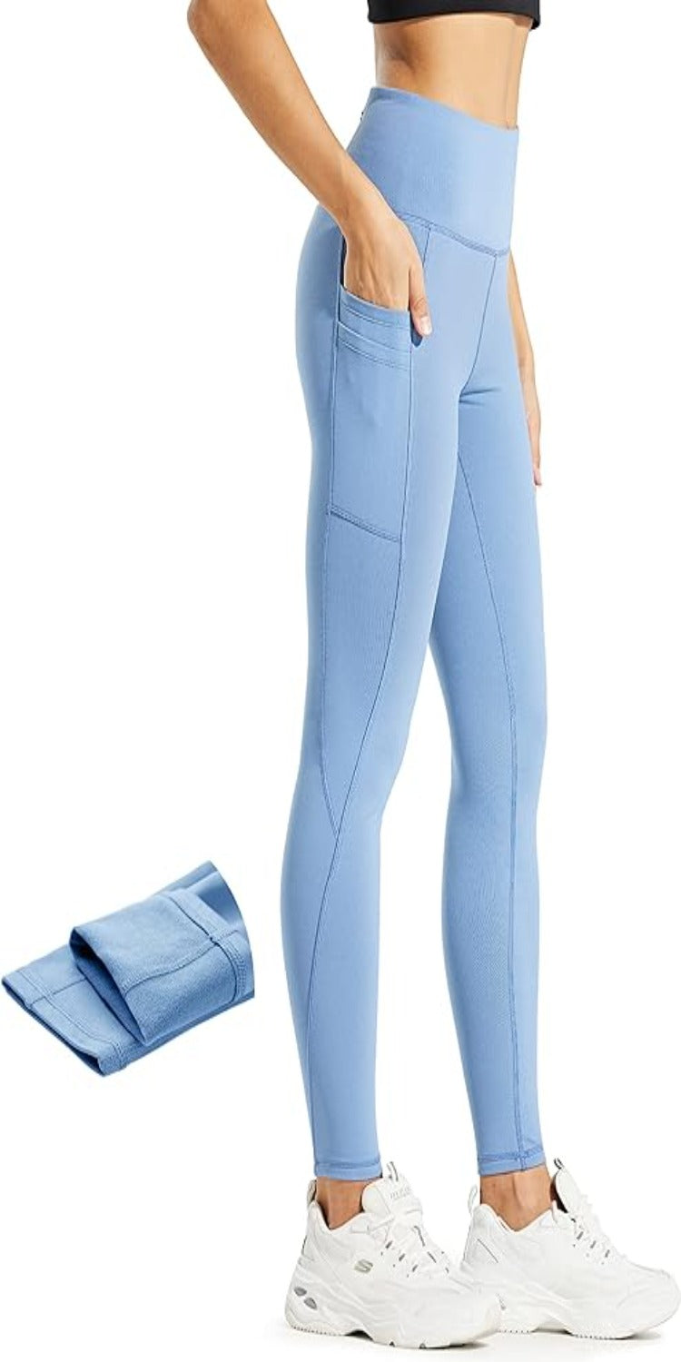 Laad afbeelding in Galerijviewer, Een vrouw in profiel draagt &quot;Warm, comfortabel en waterafstotend: de perfecte stille legging voor dames&quot;: een blauwe legging met hoge taille, een zijzak en zichtbare witte sneakers. Deze warme leggings zorgen voor warmte en comfort. Een extra afbeelding toont gevouwen leggings.
