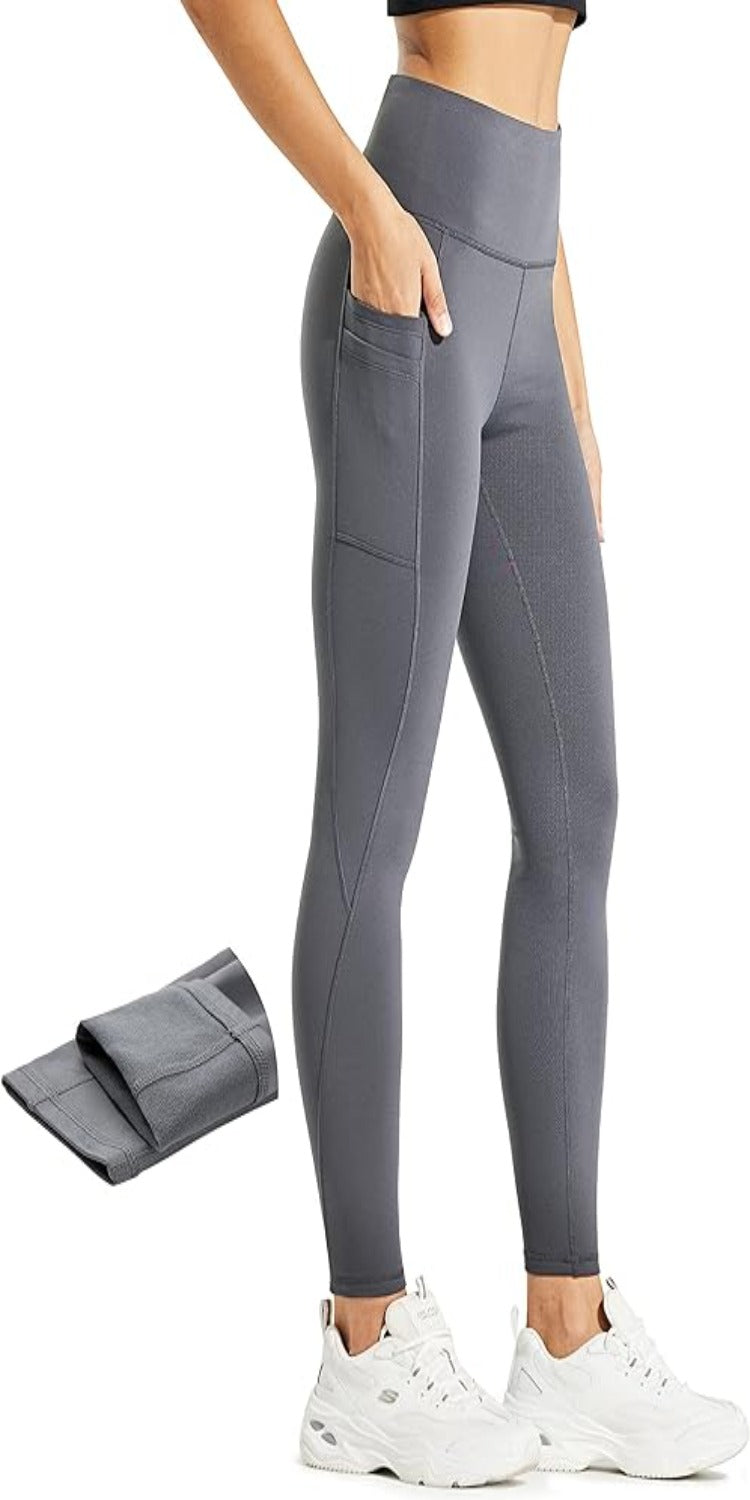 Laad afbeelding in Galerijviewer, Een persoon in een grijze thermische legging met hoge taille, zijzakken en witte sneakers. Ernaast wordt een opgevouwen paar &quot;Warm, comfortabel en waterafstotend: de perfecte hitte leggings voor dames&quot; getoond.

