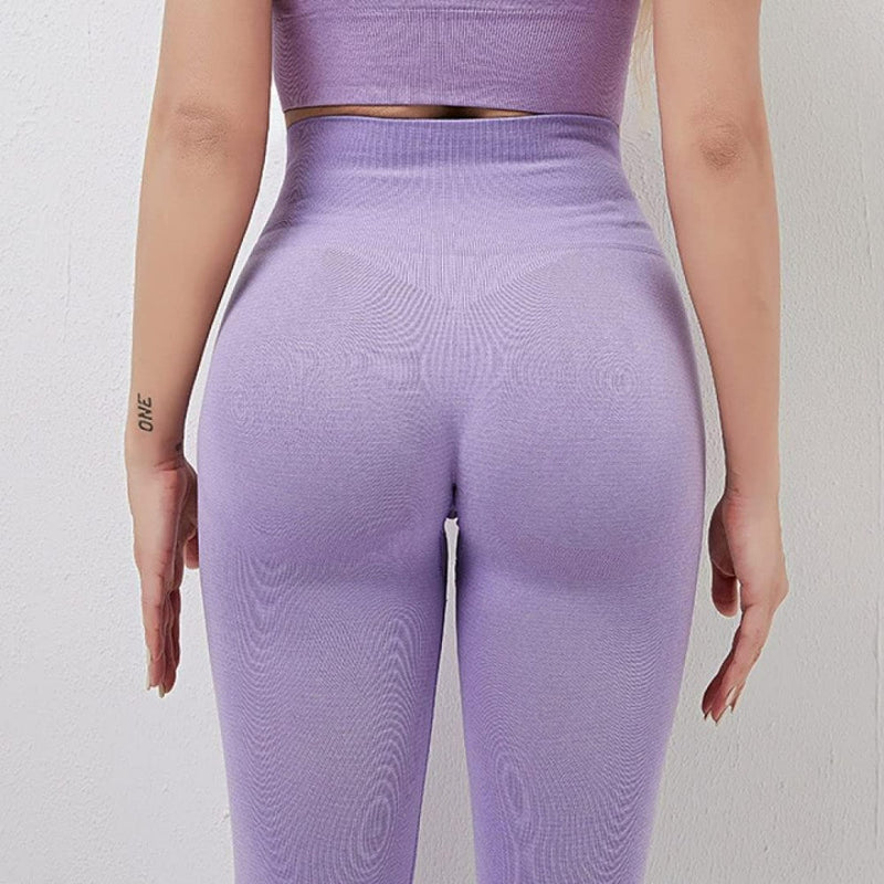Laad afbeelding in Galerijviewer, Achteraanzicht van een persoon die een &quot;de perfecte balans van stijl en comfort&quot; yogalegging draagt, in het paars met een hoog getaillleerde tailleband tegen een effen achtergrond.

